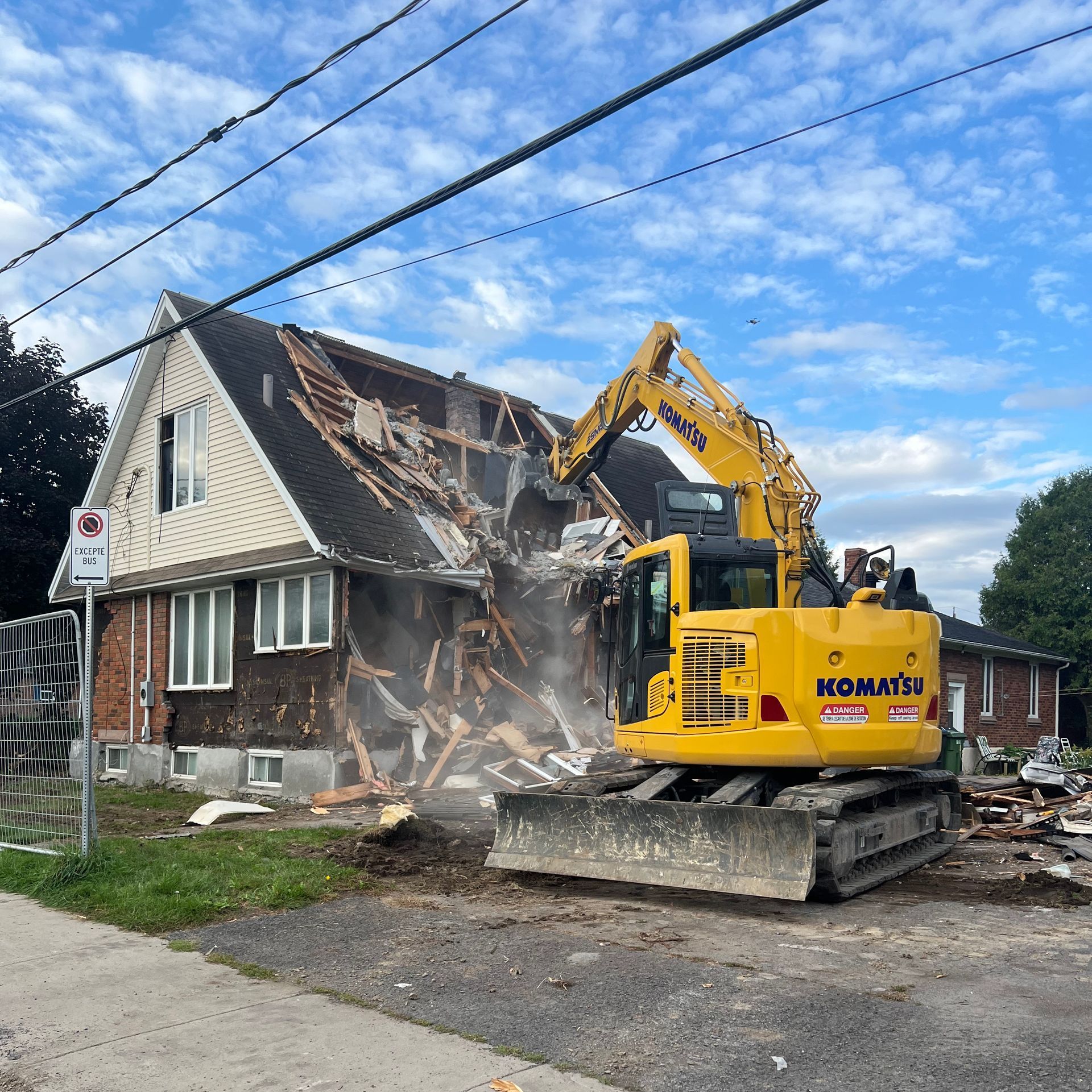 Une excavatrice jaune komatsu démolit une maison