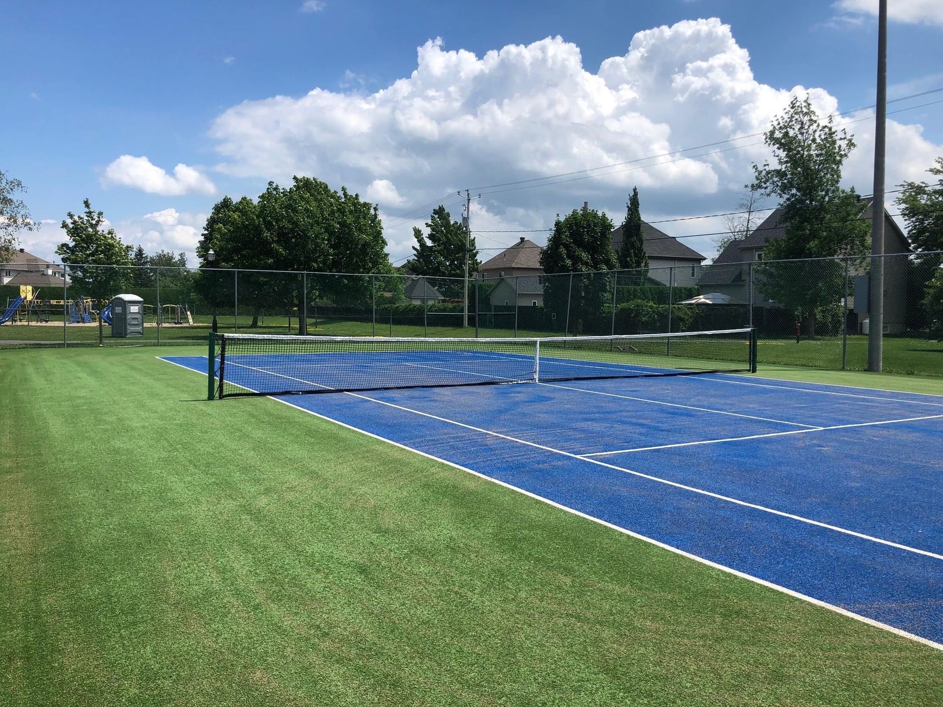 Un court de tennis bleu avec un filet au milieu.