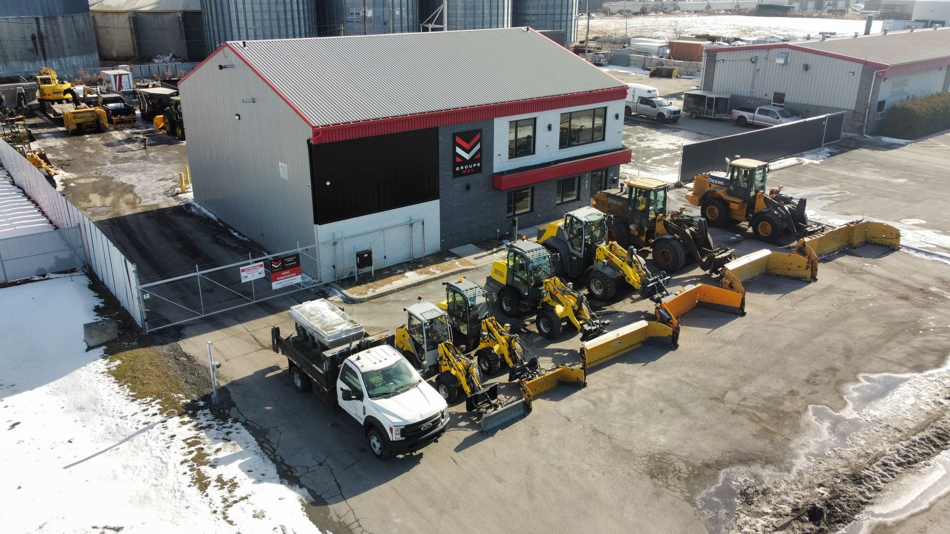 Une rangée de chasse-neige est garée devant un bâtiment.