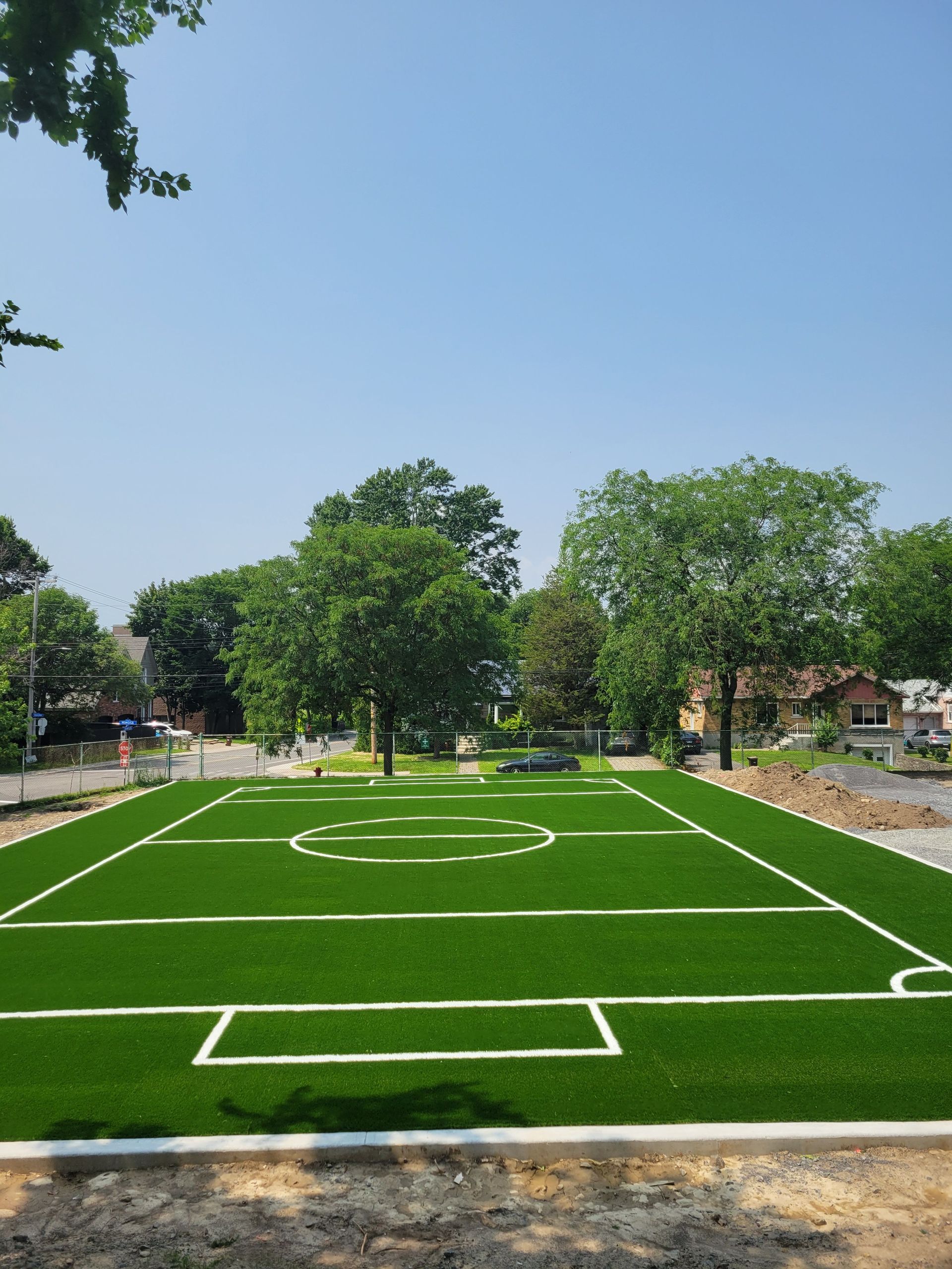 Un terrain de football avec des lignes blanches et des arbres en arrière-plan