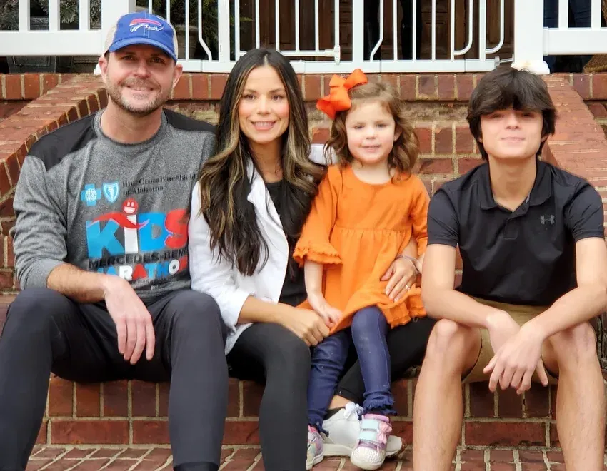 A family is posing for a picture while sitting on a set of brick steps.