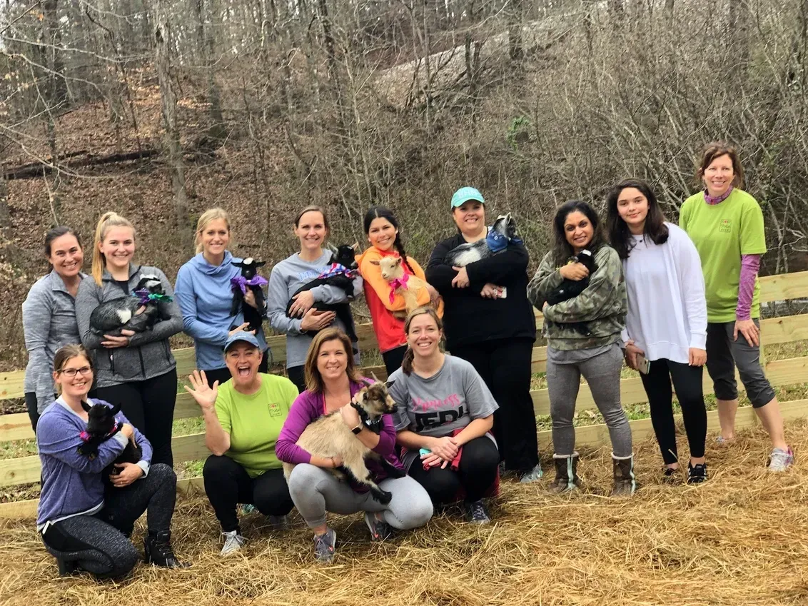 A group of women are posing for a picture with their dogs.