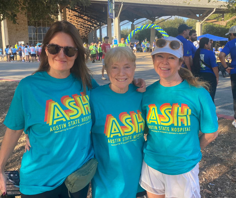 Three women wearing teal shirts with 