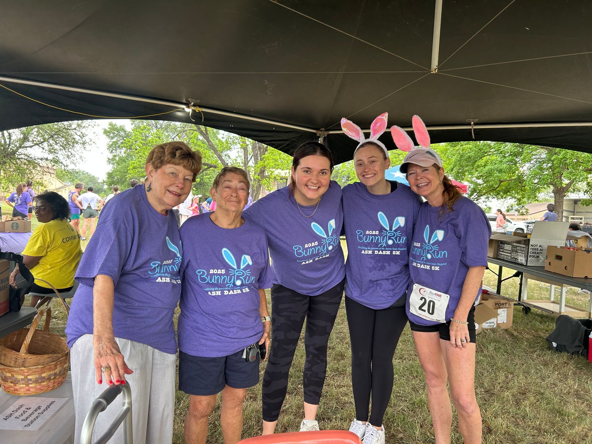 Three people standing in an office. A woman in lime green top is centered between two men in suits.