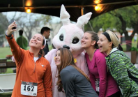 A group of women are posing for a picture with a bunny mascot.