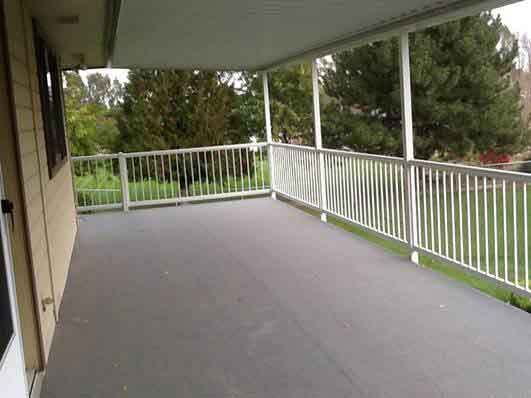 An Empty Porch With A White Railing And A Roof — Kirkland, WA — Action Installations LLC
