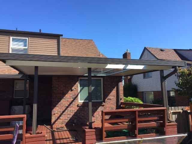 A Brick House With A Wooden Deck And A Covered Porch — Kirkland, WA — Action Installations LLC