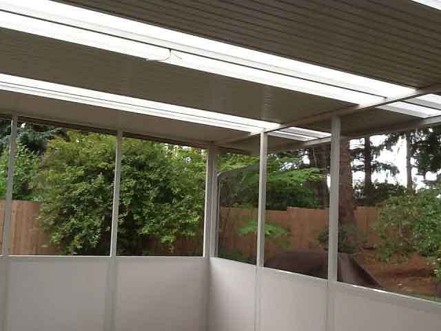 A Patio With A Clear Roof And Trees In The Background — Kirkland, WA — Action Installations LLC