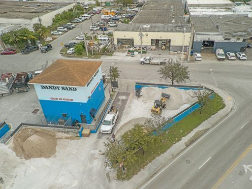 An aerial view of a sandy sand company in a city.