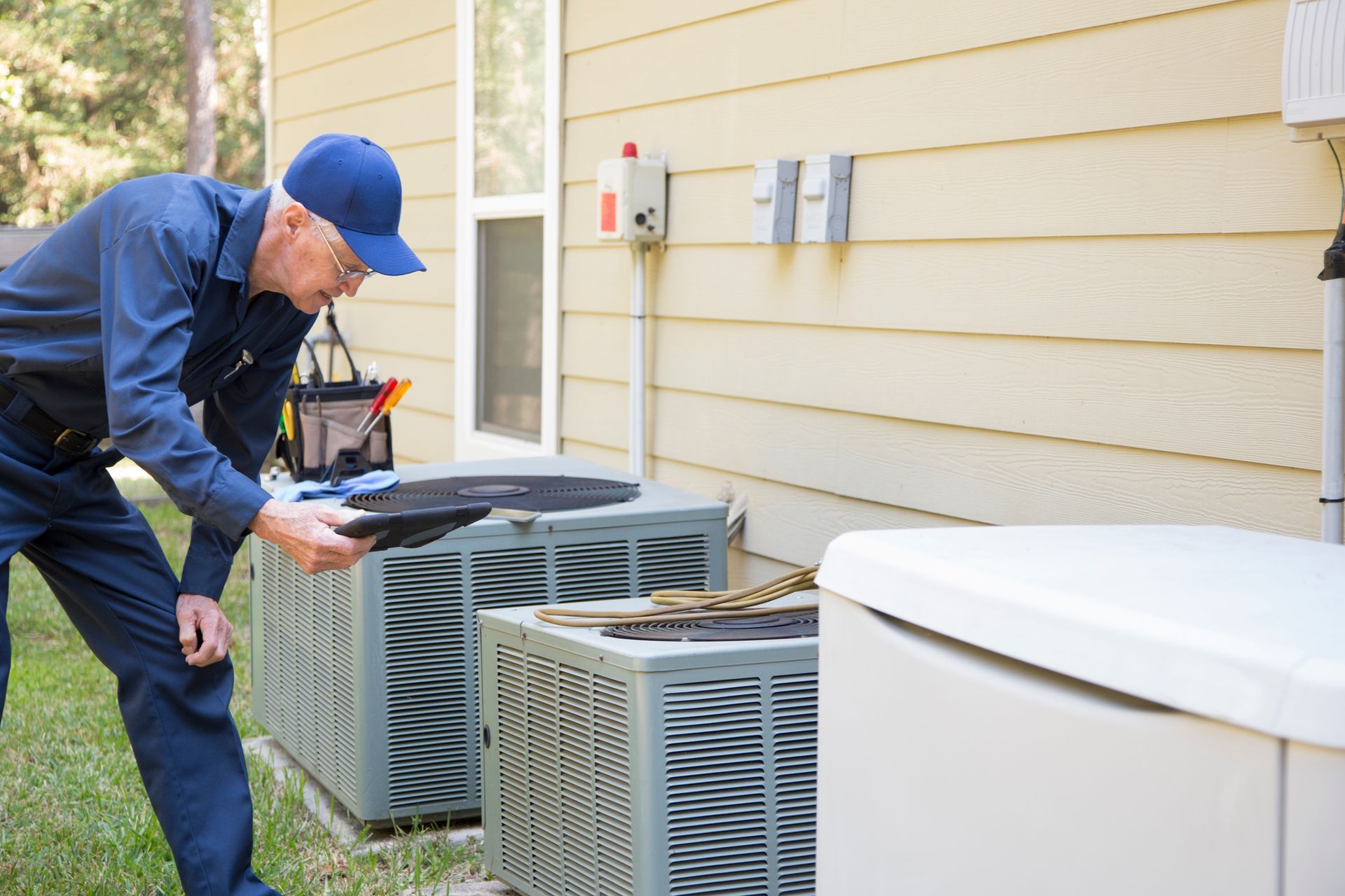 AC repair service technician inspecting outdoor condenser unit at residential property.