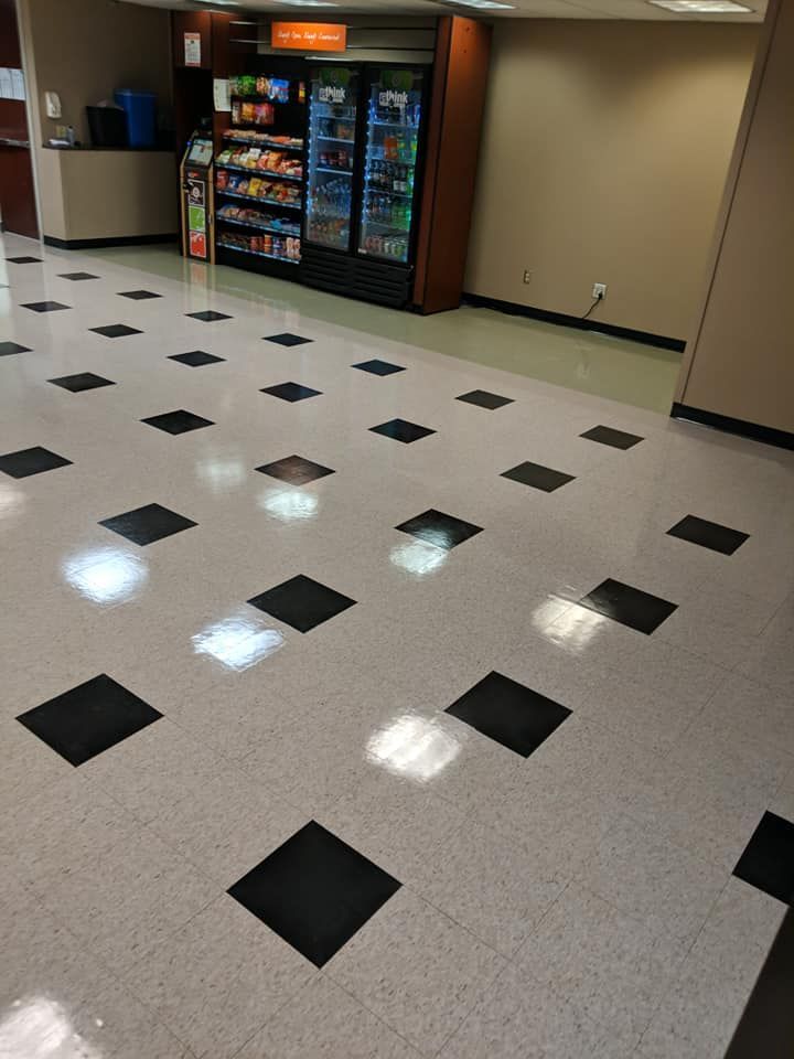 Checkerboard-patterned floor in a room, tan walls, and overhead lights.