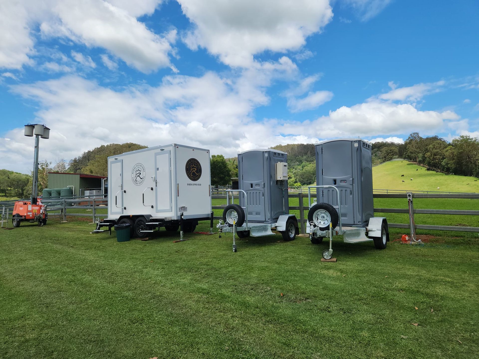 Three Trailers on Green Grass Under a Partly Cloudy Sky — Royal Flush Luxury Toilet, Portaloo & Shower Hire in Gympie, QLD