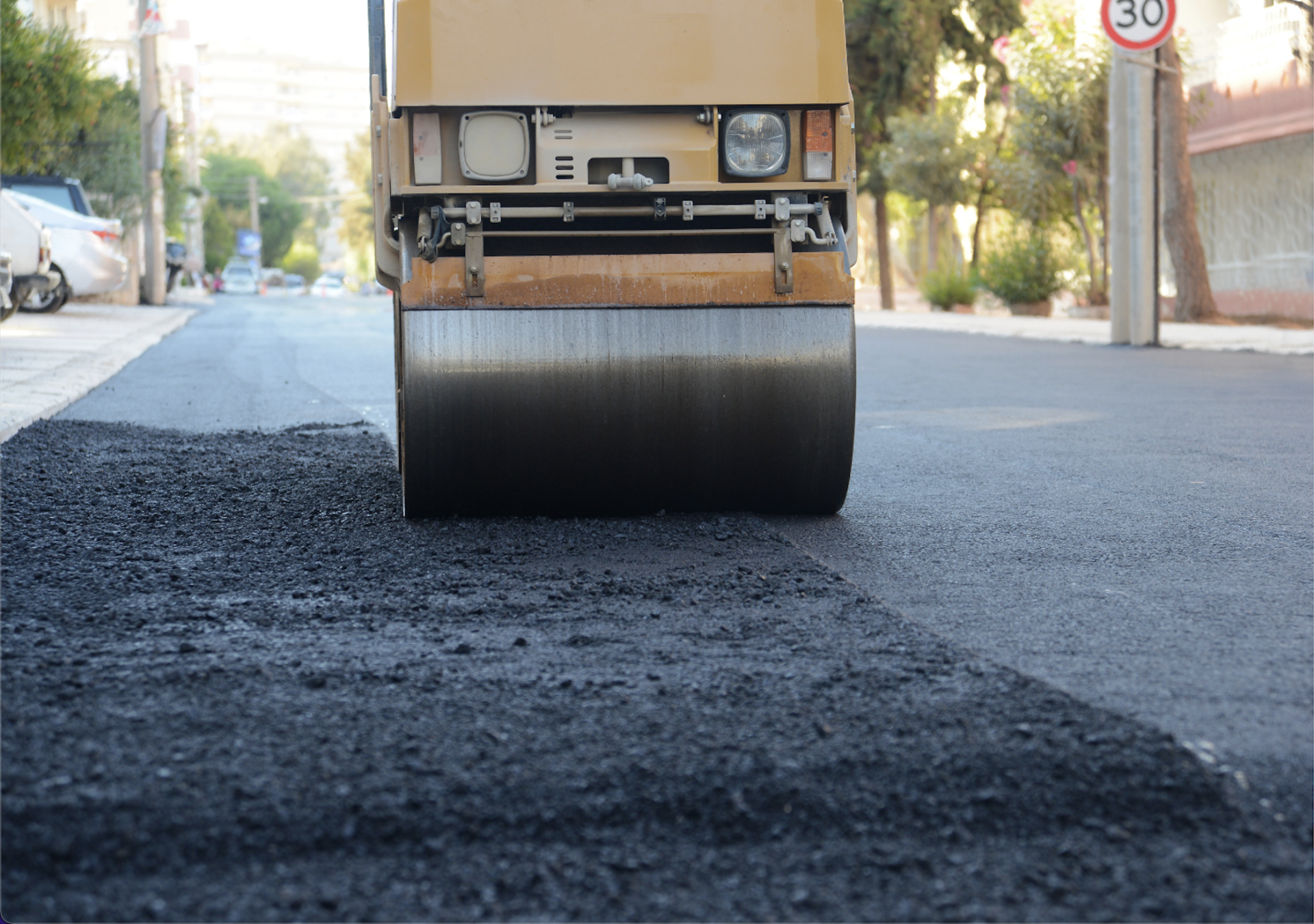 A roller is rolling asphalt on a street.