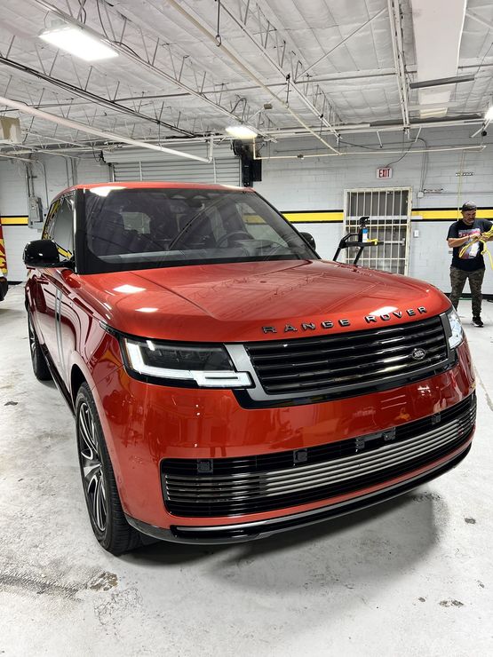 A red range rover is parked in a garage.