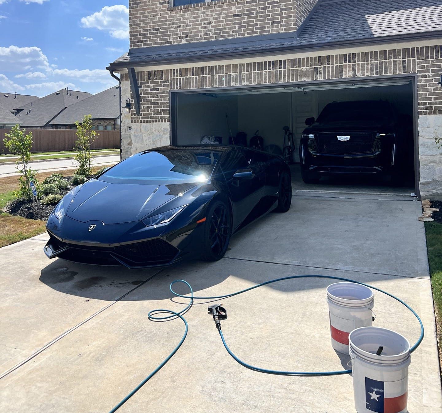 A blue sports car is parked in a garage next to two buckets