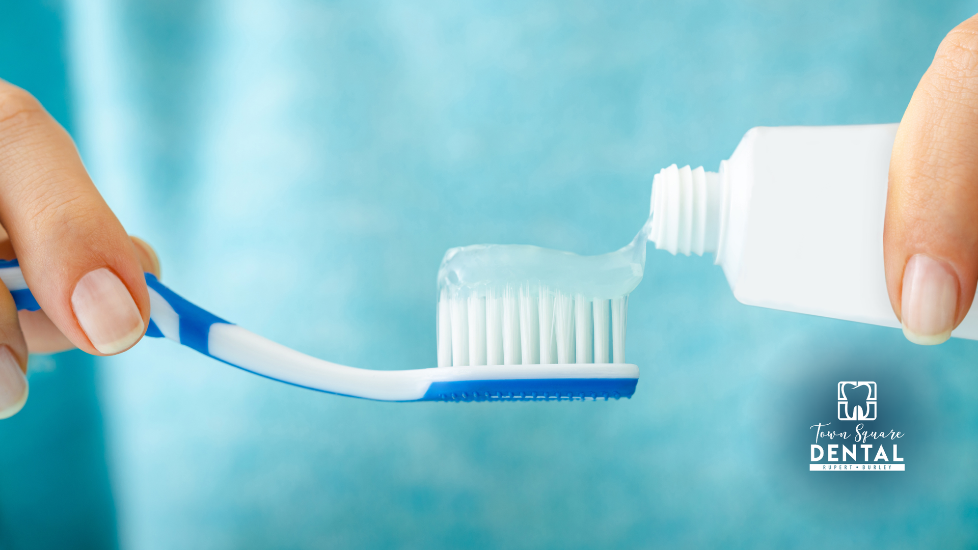 Person squeezing toothpaste onto a toothbrush; close-up on hands and oral hygiene tools.