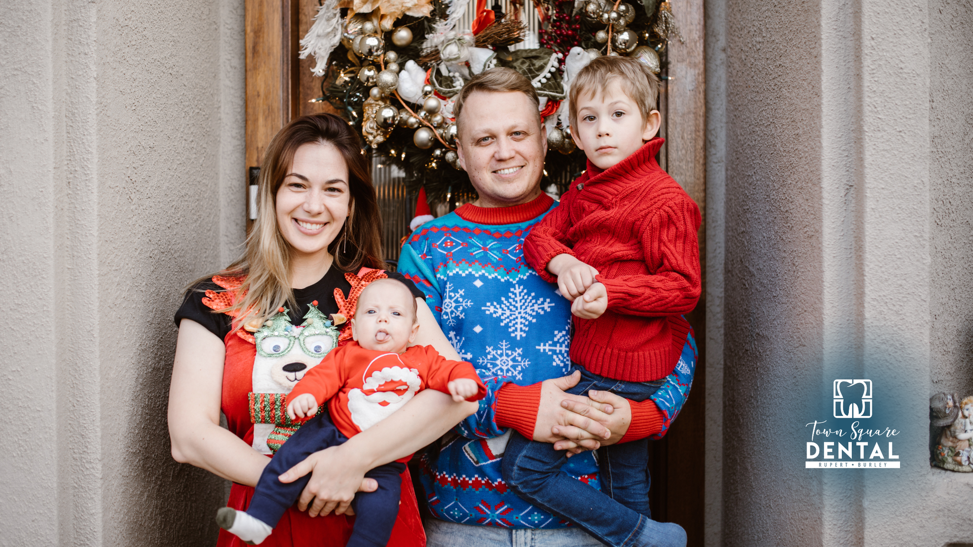 A family is posing for a picture in front of a christmas tree.