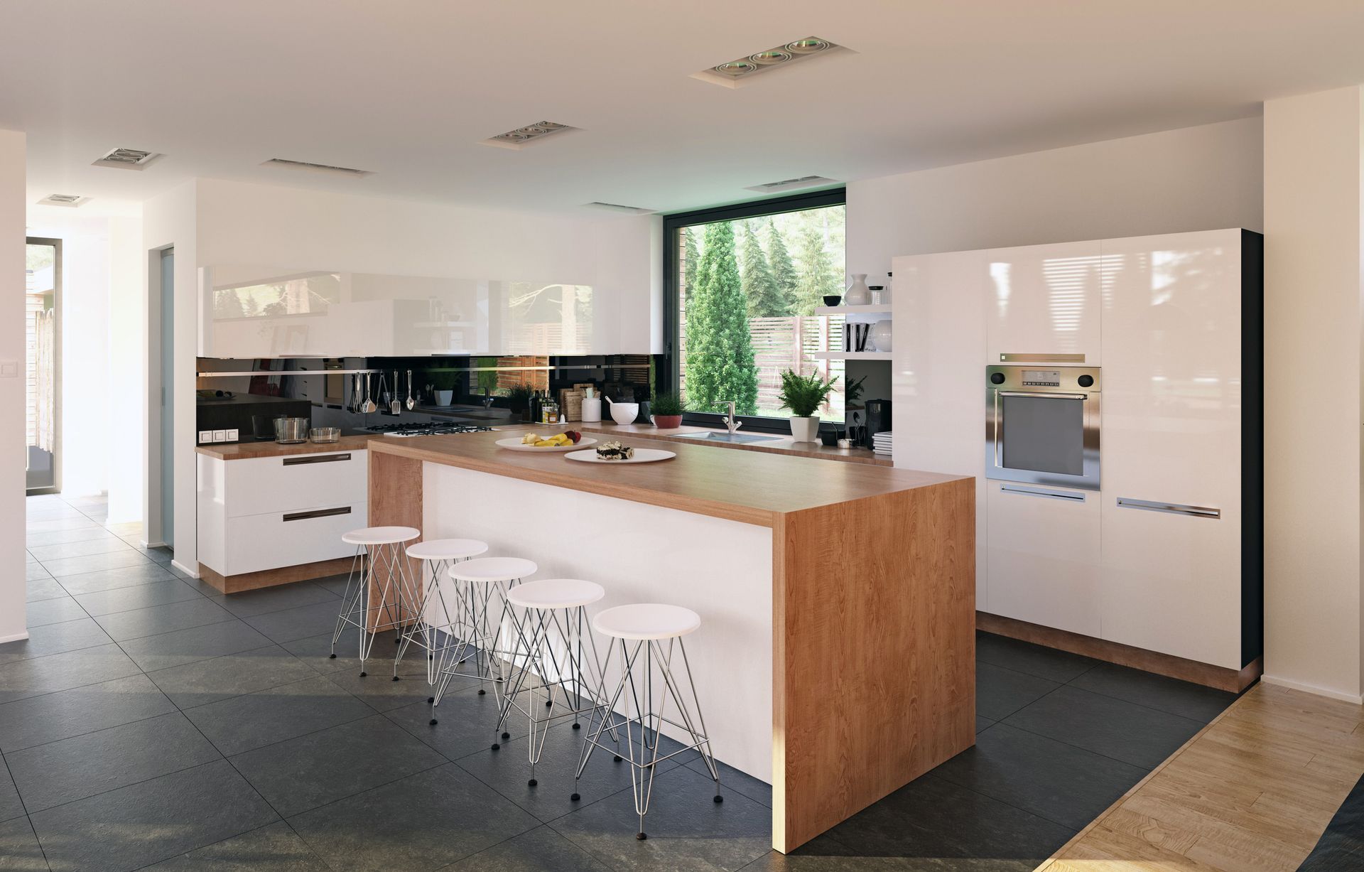 Modern kitchen with white cabinets, wood island, stools, and large window overlooking trees.