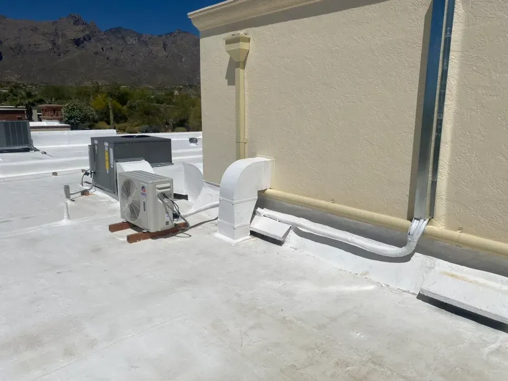 A white roof with a lot of air conditioners on it.