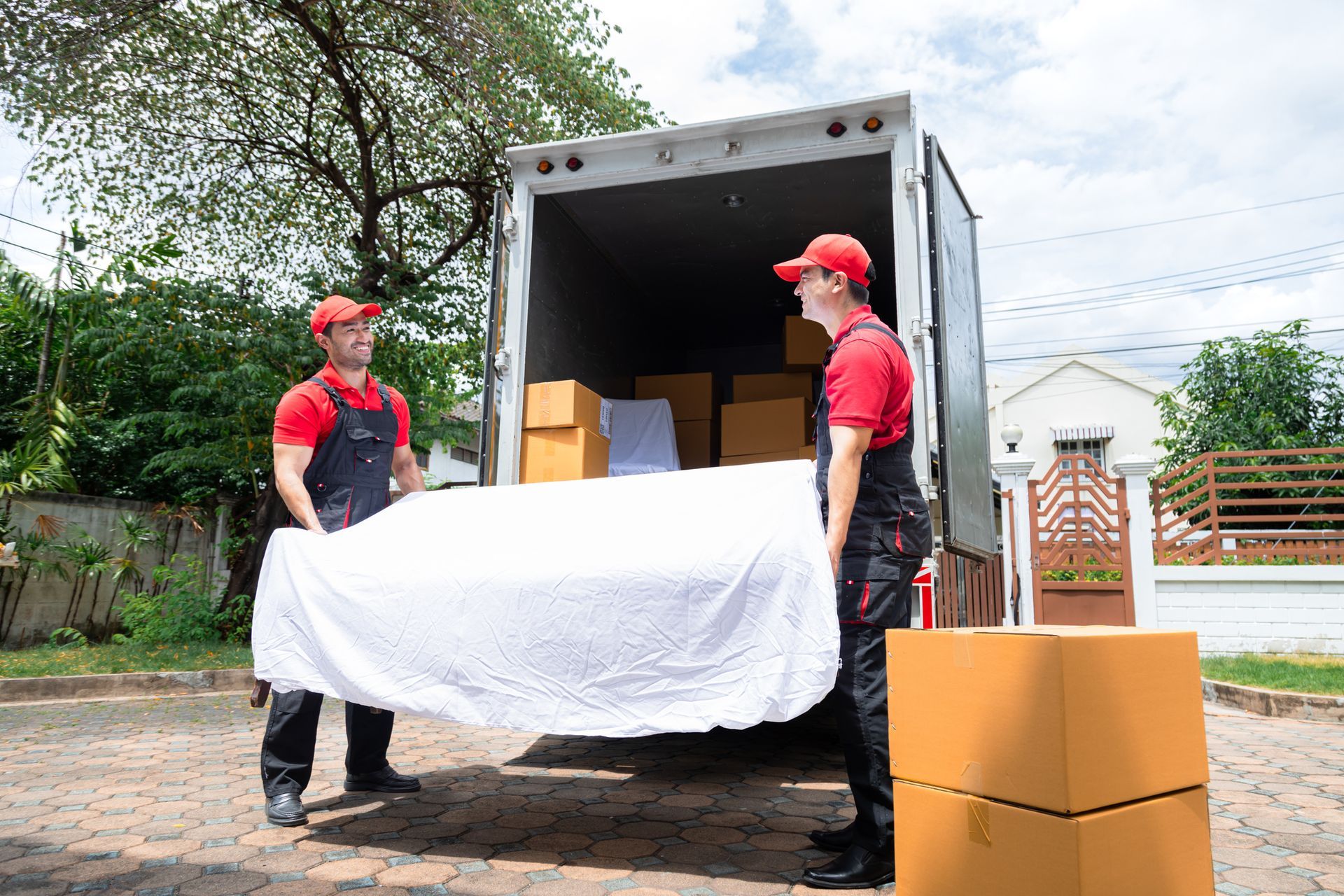 Two men are carrying a bed into a moving truck.
