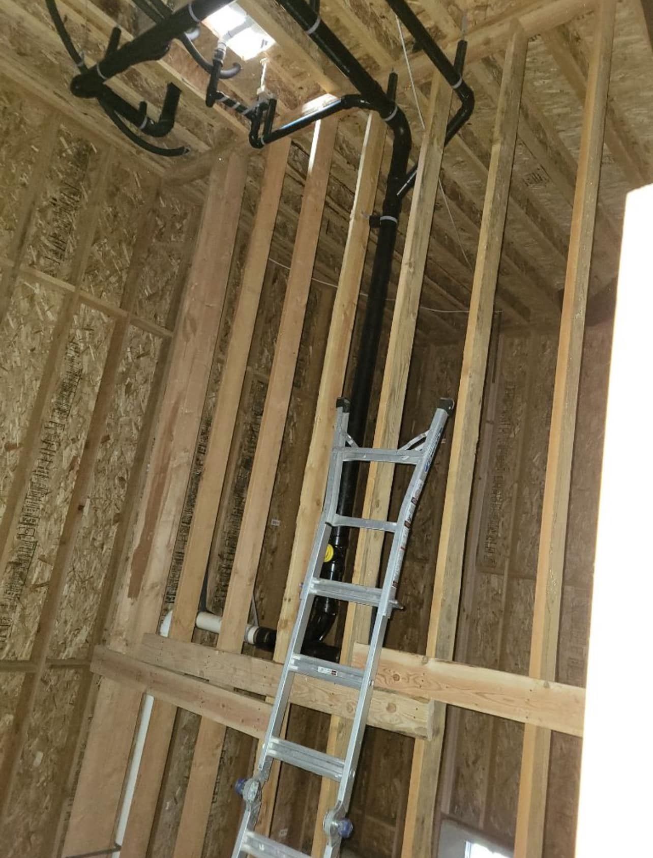 A ladder is hanging from the ceiling of a building under construction