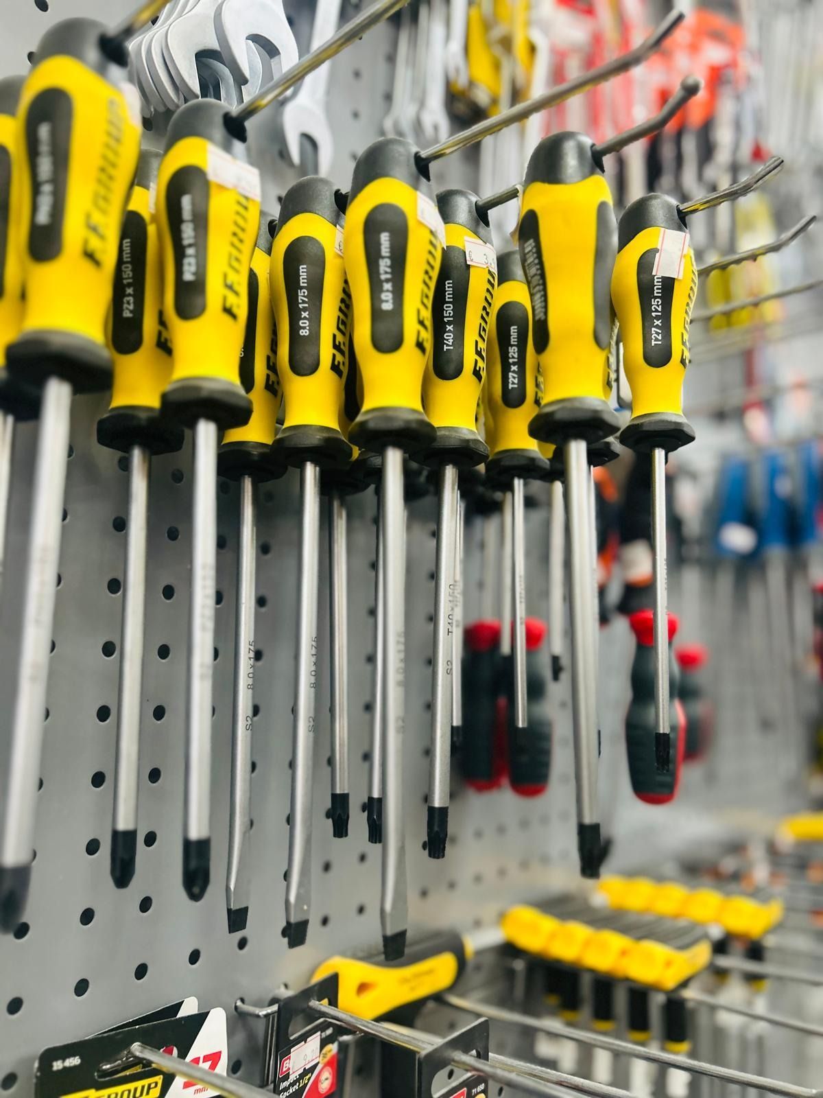 Una collezione di vari apparecchi di illuminazione per interni, lampade e lampadine decorative disposte su un tavolo di legno in un negozio.