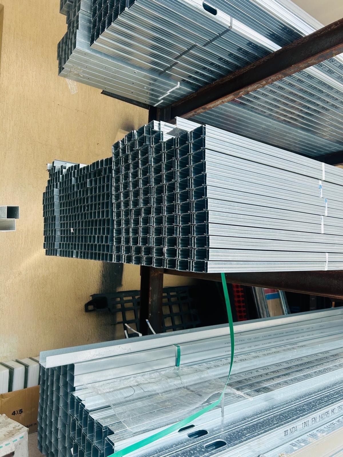 Un insieme di componenti di un sistema di sicurezza domestica, tra cui telecamere, un monitor, un pannello di controllo e cavi, su una superficie grigia.