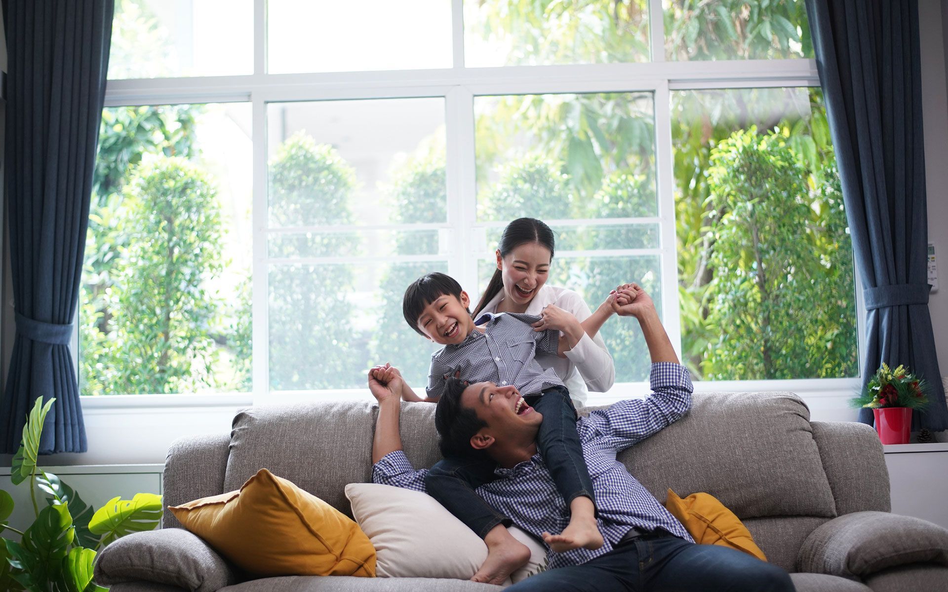 A family is playing on a couch in a living room.
