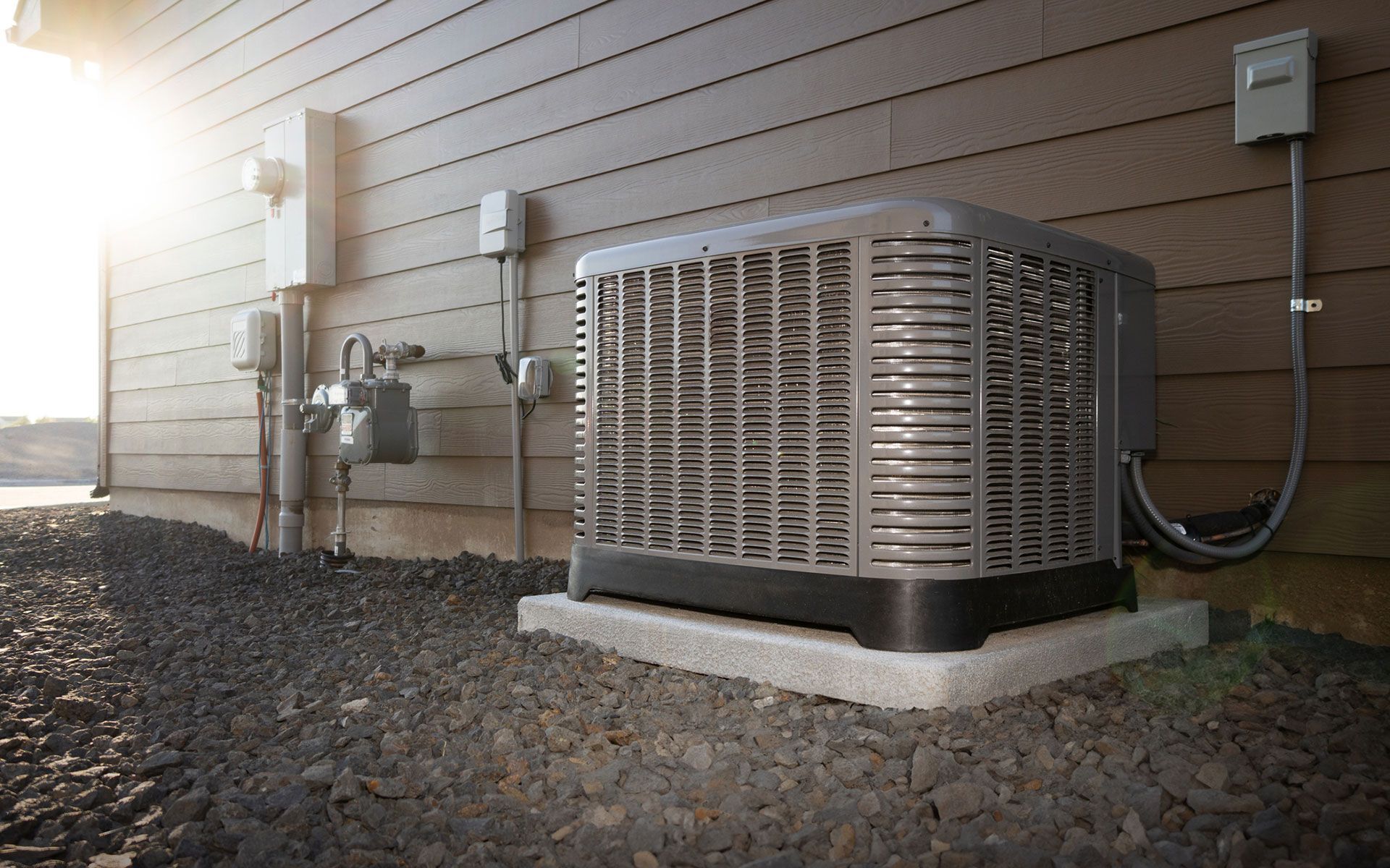 An air conditioner is sitting on the side of a house.