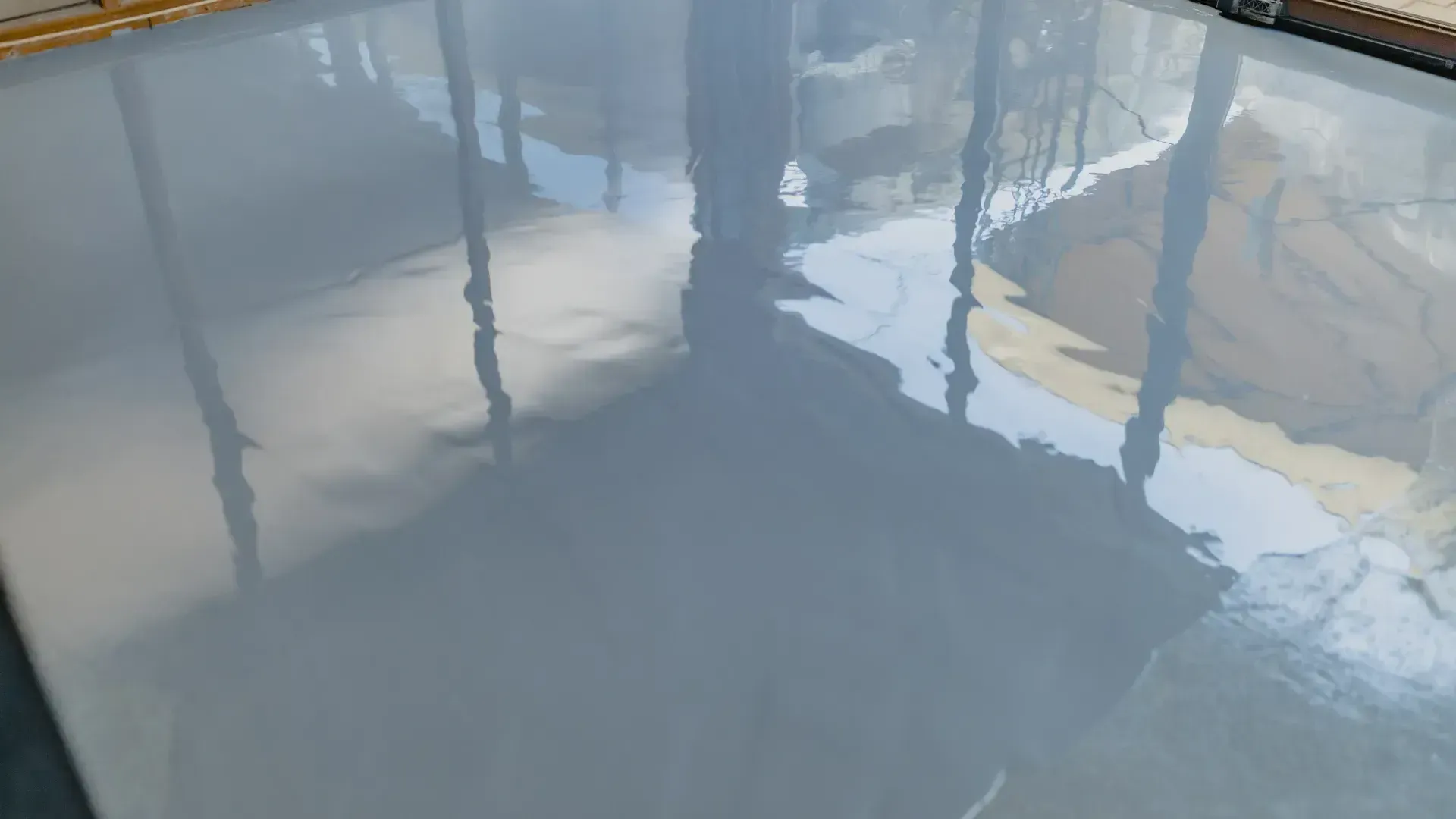 Newly poured gray epoxy floor reflecting the surrounding environment.