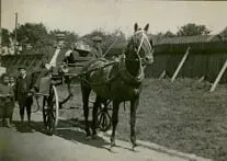 A black and white photo of a horse drawn carriage.