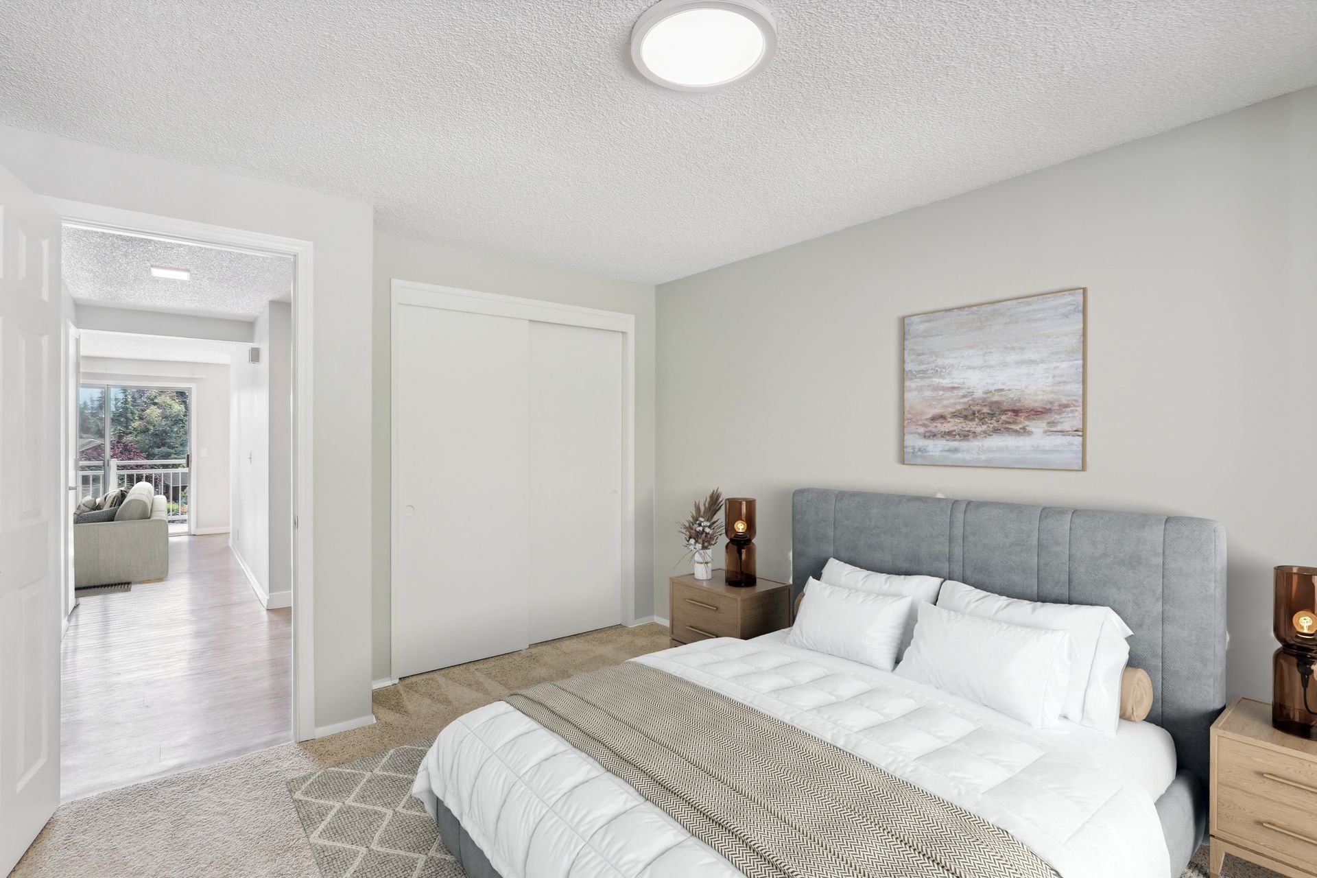 Bedroom with a gray upholstered headboard, white bedding, two nightstands, and a white closet door.