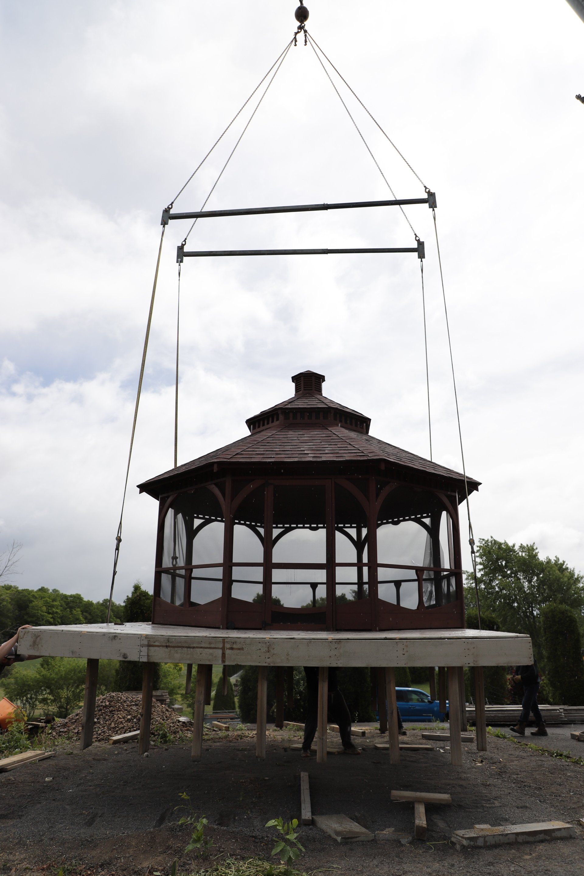 Gazebo soulevé par grue pour installation sur une fondation en béton, en extérieur.