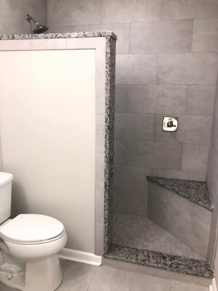 A bathroom with a toilet and a walk in shower.