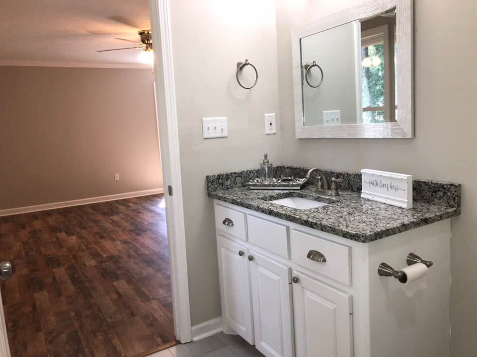 A bathroom with a sink and a mirror.
