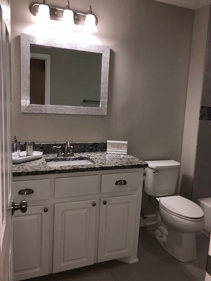 A bathroom with a sink , toilet and mirror