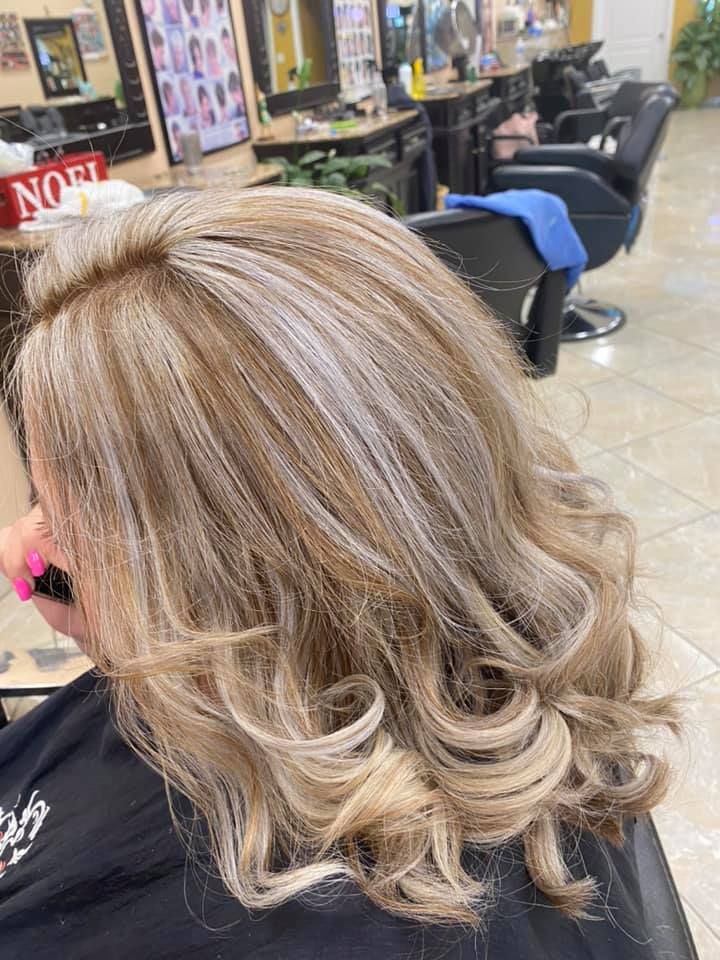 Woman with blonde and light brown wavy hair in a salon.