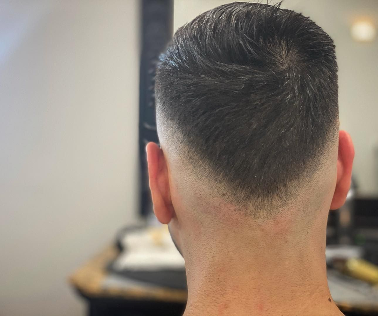 Back view of a man with a faded haircut and a clean neckline.
