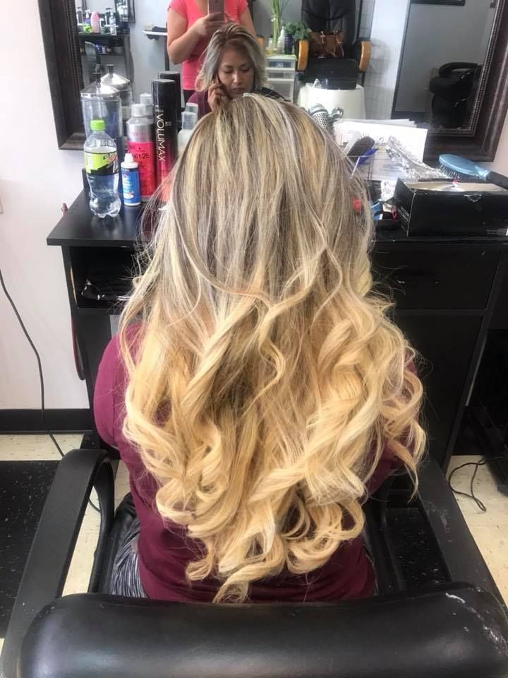 Woman with blonde ombre wavy hair in a salon.