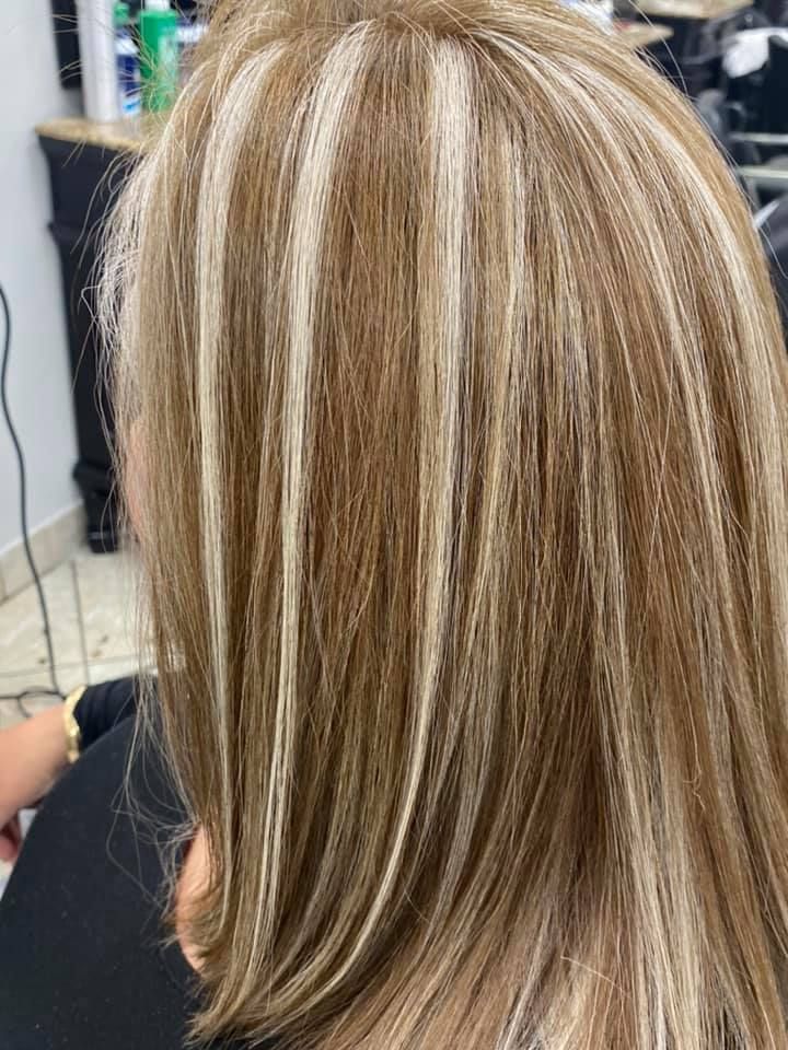 Woman with light brown hair with thick blonde highlights.