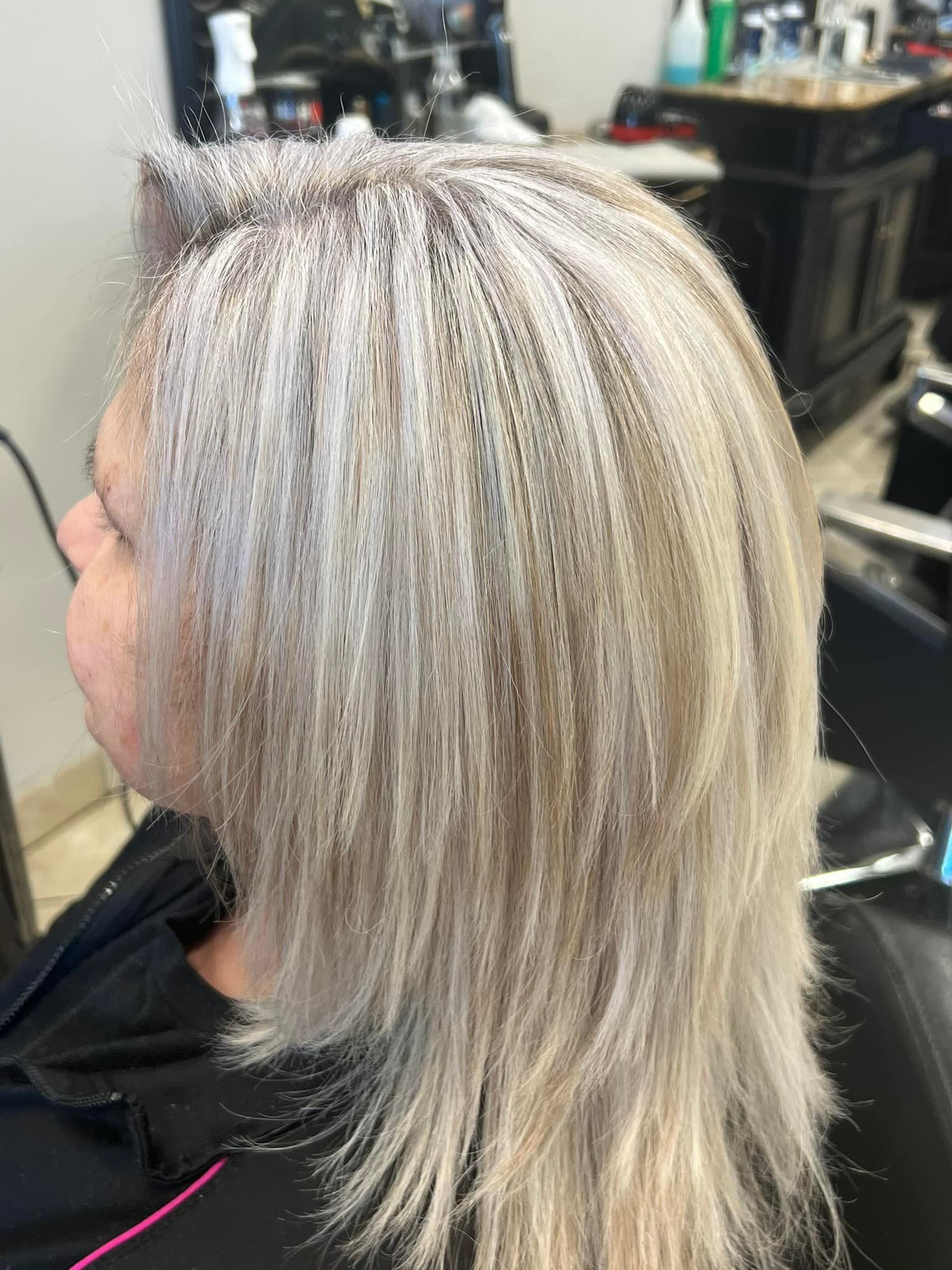 Woman with layered, light blonde hair in a salon.