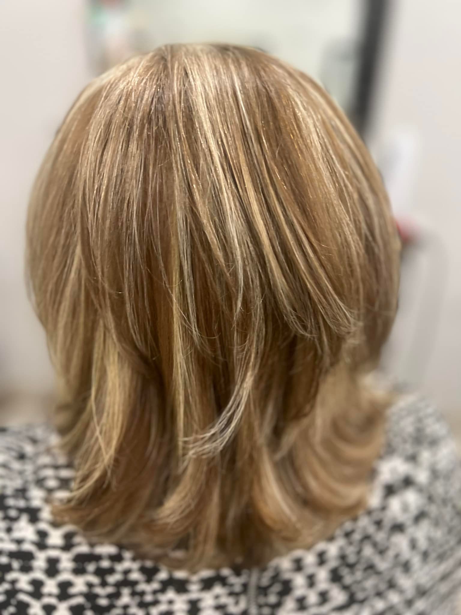 Blonde hair with crimped highlights and layered cut, viewed from the back.