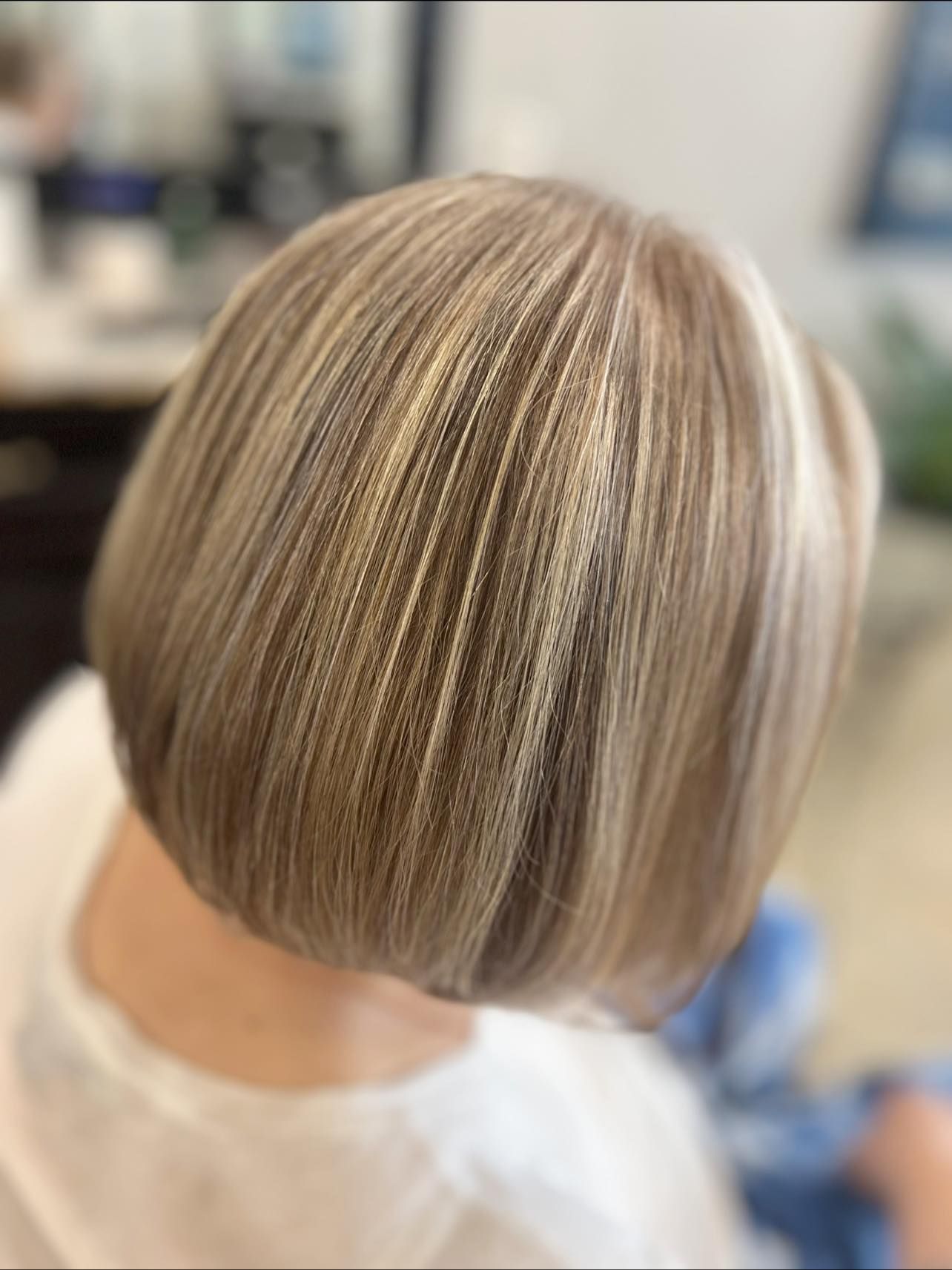Blonde bob haircut with highlights; seated person from the back.
