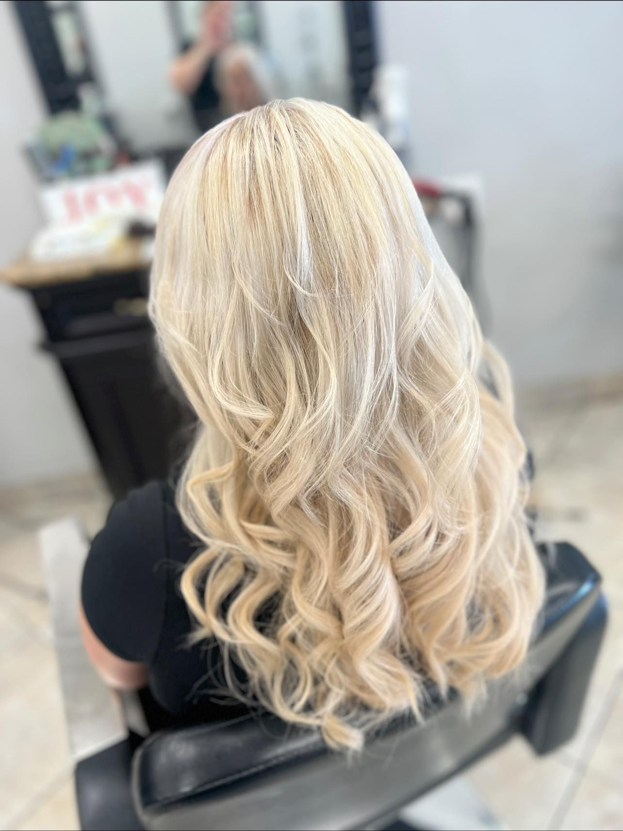 Woman with long, wavy blonde hair, styled in a salon.