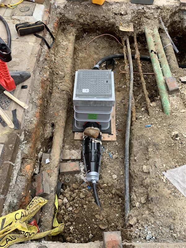 A pipe is being installed in a hole in the ground.