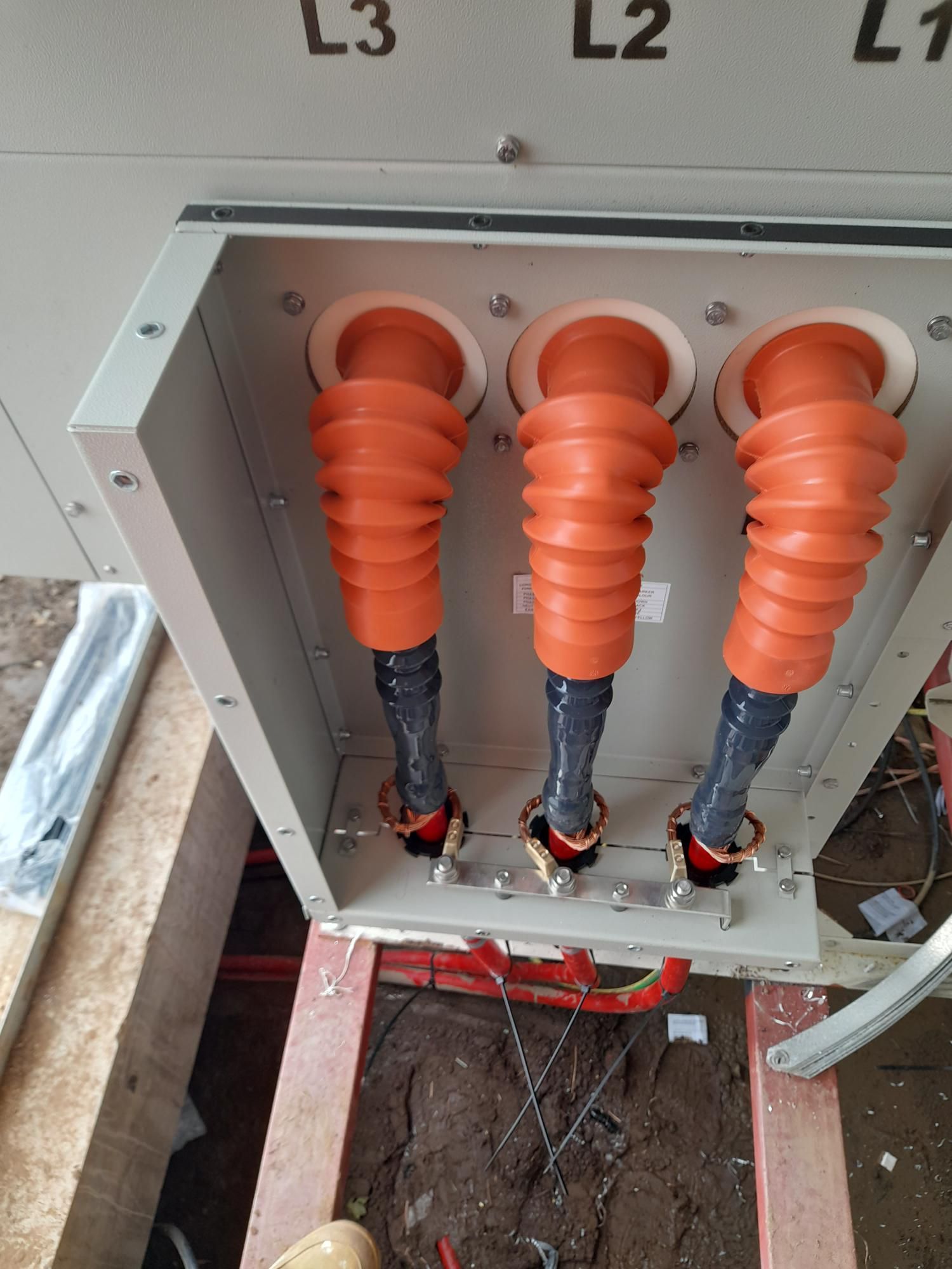 A box with three orange pipes inside of it.