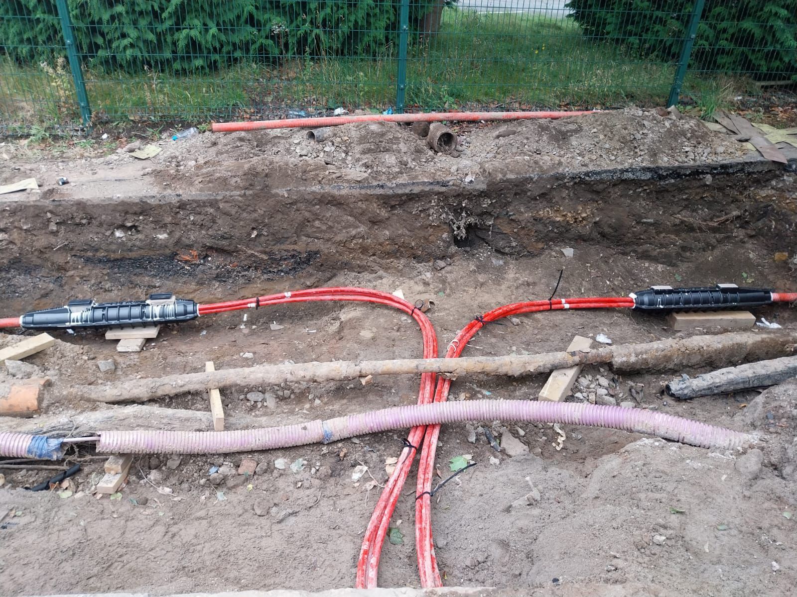 A bunch of electrical wires are laying in the dirt.