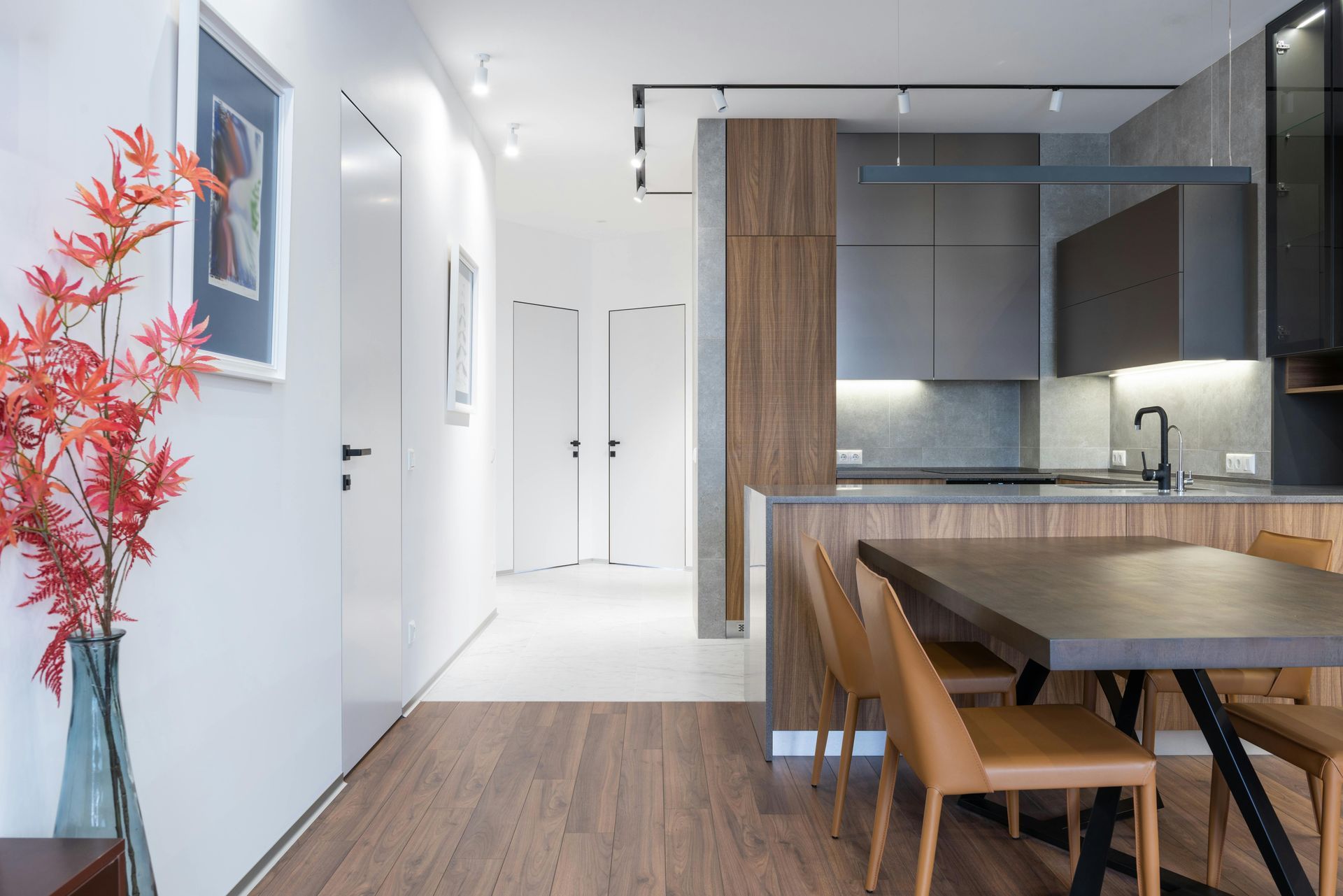a modern kitchen and dining room with white walls and wooden-panelling