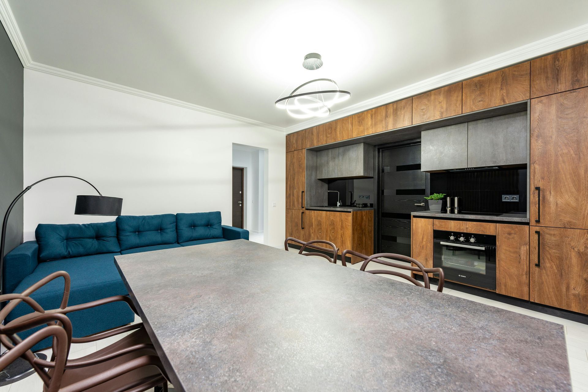kitchen with long grey table and blue couch