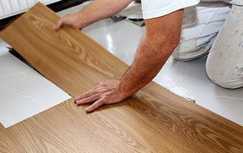 Man Installing Vinyl — Flooring Company in Gaithersburg, MD Man Installing Vinyl — Flooring Company in Gaithersburg, MD